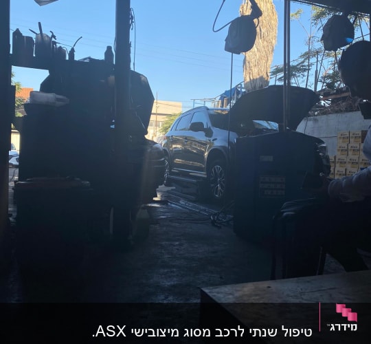 רכב עם מכסה מנוע פתוח במוסך